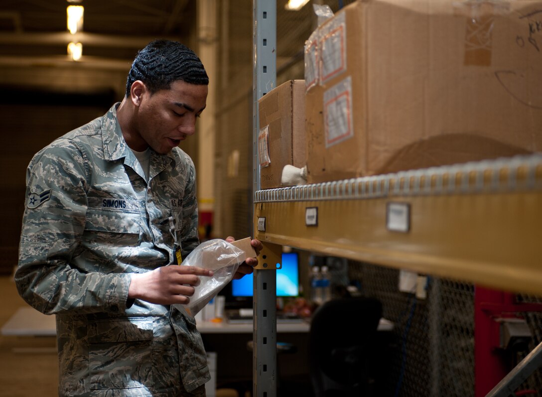 Airman 1st Class Dairon Simons, 28th Logistics Readiness Squadron flight service center technician, calls out part numbers while filling bags with parts at Ellsworth Air Force Base, S.D., March 28, 2013. The flight service Airmen build part and accessory kits for multiple base organizations to reduce part delivery time. (U.S. Air Force photo by Airman 1st Class Alystria Maurer/Released)