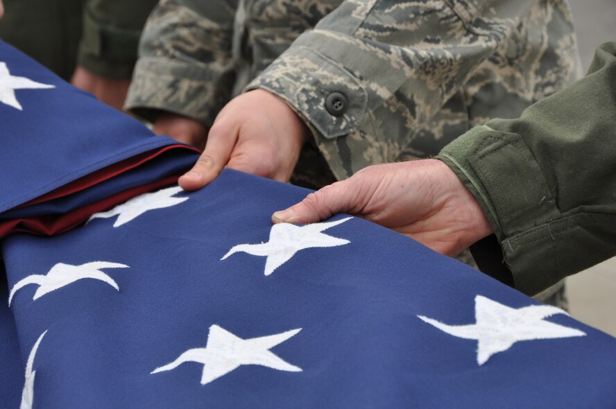 Niagara Falls Reserve Station 914th Airlift Wing personnel participate in the ceremonial folding of the flag, April 7, 2013 Niagara Falls, NY. In the Armed Forces of the United States, at the ceremony of retreat the flag is lowered, folded in a triangle fold and kept under watch throughout the night as a tribute to our nation's honored dead. (U.S. Air Force photo by Staff Sgt Stephanie Clark) 