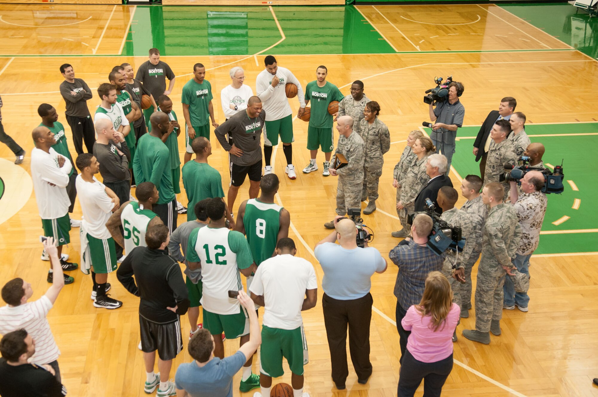 WALTHAM, Mass. – Col. Lester A. Weilacher, 66th Air Base Group commander, along with other military members from Hanscom, huddle up to present an American flag to coach Doc Rivers and the rest of the Boston Celtics during a practice April 4. The flag was flown over Afghanistan on a C-17 aircraft on Veterans Day last year by Lt. Col. Romero Reid, 66th Air Base Group deputy commander. (U.S. Air Force photo by Rick Berry)