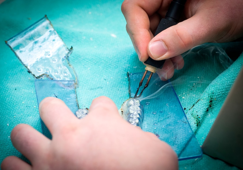 U.S. Air Force Airman 1st Class Justin Shaw, 23d Aerospace Medicine Squadron dental laboratory technician, uses a heated knife to cut out a bleach tray at Moody Air Force Base, Ga., April 9, 2013. There is typically one dental laboratory technician for every 4.5 dentists at any given base. (U.S. Air Force photo by Senior Airman Jarrod Grammel/Released)
