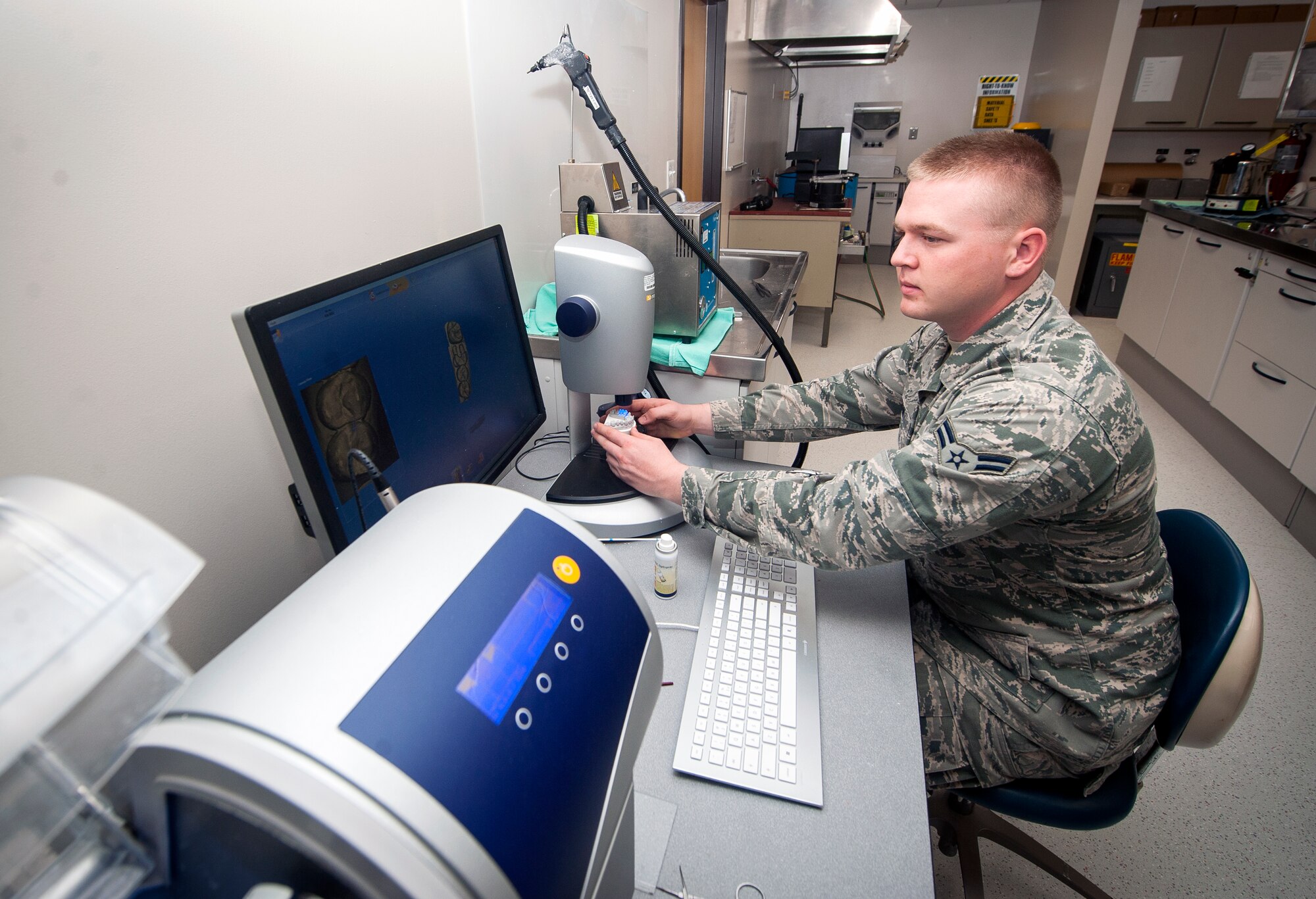 U.S. Air Force Airman 1st Class Justin Shaw, 23d Aerospace Medicine Squadron dental laboratory technician, prepares a computer-aided design/ computer-aided manufacturing (CAD/CAM) machine to make replacement crown at Moody Air Force Base, Ga., April 9, 2013. The CAD/CAM machine is accurate within 10 microns, or one-one hundredth of a millimeter, and is capable of restoring teeth within one sitting instead of the multiple visits required for older methods. (U.S. Air Force photo by Senior Airman Jarrod Grammel/Released)
