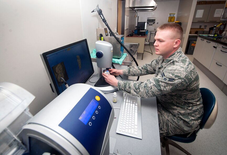 U.S. Air Force Airman 1st Class Justin Shaw, 23d Aerospace Medicine Squadron dental laboratory technician, prepares a computer-aided design/ computer-aided manufacturing (CAD/CAM) machine to make replacement crown at Moody Air Force Base, Ga., April 9, 2013. The CAD/CAM machine is accurate within 10 microns, or one-one hundredth of a millimeter, and is capable of restoring teeth within one sitting instead of the multiple visits required for older methods. (U.S. Air Force photo by Senior Airman Jarrod Grammel/Released)
