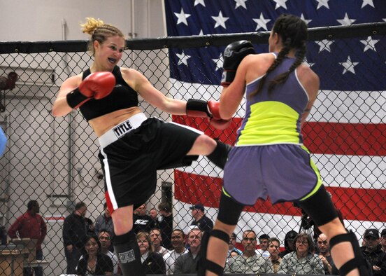 Kickboxers Elisha Helsper (right) protects herself from opponent Aerial Beck’s left kick during a kickboxing bout at the Malmstrom Air Force Base 3-Bay Hangar on April 5. Helsper lost the fight by split decision. (U.S. Air Force photo/Airman 1st Class Katrina Heikkinen)