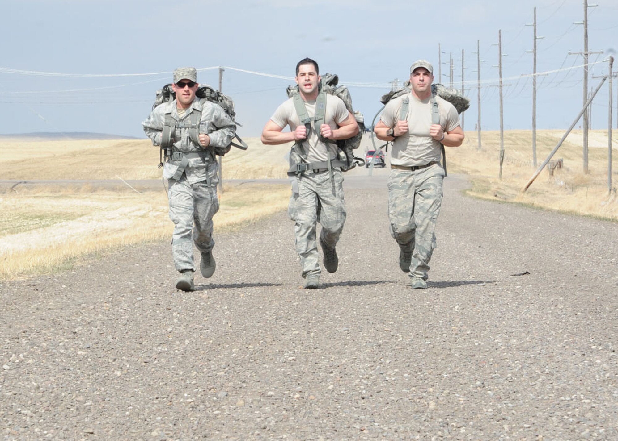 (From left) Senior Airman Trey Stone, 741st Missile Security Forces Squadron member, Senior Airman Jordan Cunningham, 341st Civil Engineer Squadron pavement and construction equipment apprentice, and Staff Sgt. Ryan Krastins, 341st Security Forces Group tactical response force member, push through pain during the last stretch of an 8.3-mile ruck march held April 3. Spearheaded by the 341st SFG, the all-day event including a CrossFit workout, remembrance ceremony and 8.3-mile ruck march was held to honor fallen Staff Sgt. Travis Griffin five years after he paid the ultimate sacrifice in combat. (U.S. Air Force photo/Airman 1st Class Katrina Heikkinen)
