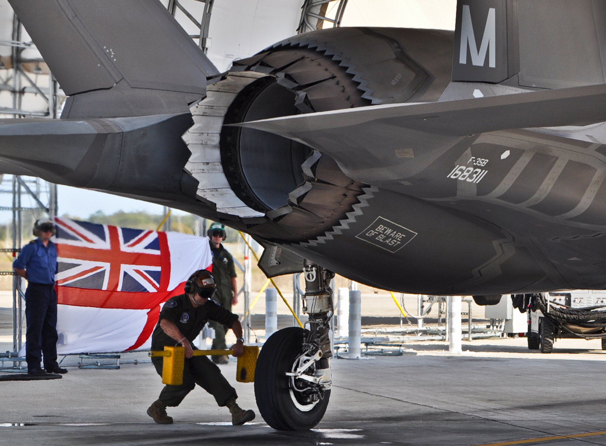 A maintainer places chocks onto the rear wheel of a United Kingdom F-35B Lightning II after a sortie at Eglin Air Force Base, Fla., April 10. UK pilot, Lt. Cmdr. Ian Tidball, became the first Royal Navy student-pilot to fly the sortie. He touched down after a successful training sortie.  Tidball has flight experience in the British Sea Harrier and the F-18 Super Hornet.  (U.S. Air Force photo/Maj. Karen Roganov)