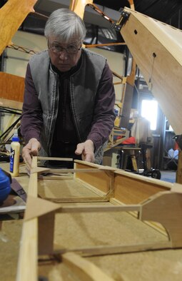 Gary White, Waco glider restoration project volunteer, glues a part into place at Whiteman Air Force Base, Mo., April 2, 2013. Whiteman was donated parts of 40 gliders to use in restoring one on base. (U.S. Air Force photo by Airman 1st Class Bryan Crane/Released)