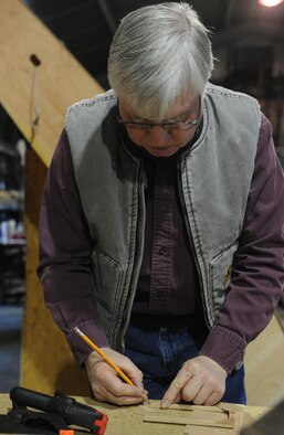 Gary White, Waco glider restoration project volunteer, marks a piece of wood while working on the Waco glider at Whiteman Air Force Base, Mo., April 2, 2013. The Waco CG-4A glider was the most widely used U.S. troop/cargo glider of World War II. (U.S. Air Force photo by Airman 1st Class Bryan Crane/Released)