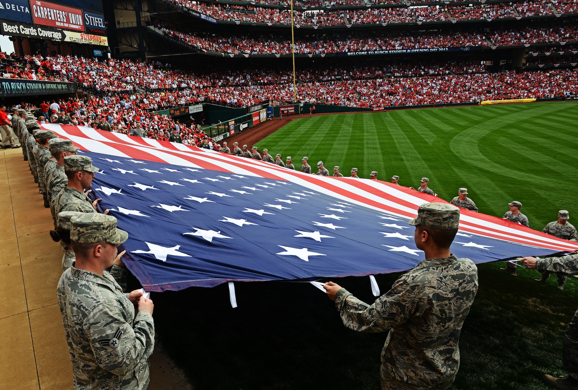 Airmen from the 375th Air Mobility Wing, Scott Air Force Base, Ill., present the giant American flag for nearly 50,000 fans to see at Busch Stadium, home of the St. Louis Cardinals, April 8, 2013. Scott AFB has been involved in numerous community sporting events, but this was the first time they presented the flag at the opening day of the season. The Cardinals went on to lose to the Cincinnati Reds 13-4. (U.S. Air Force photo/ Staff Sgt. Ryan Crane)