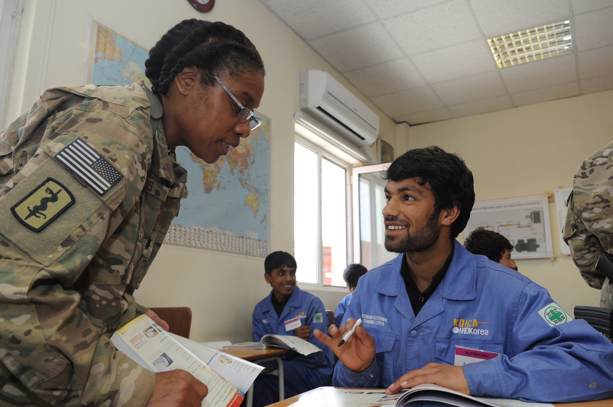 Lt. Col. Sheila Tibbs, 455th Expeditionary Medical Operations Squadron operating room officer in charge, speaks with a student at the Korean Vocational Training Center on Bagram Airfield, Afghanistan, April 10, 2013. Tibbs and her fellow Airmen are teaching conversational English to Afghan students here in addition to their lessons on skills like carpentry and plumbing at the KVTC. (U.S. Air Force photo/Staff Sgt. David Dobrydney)