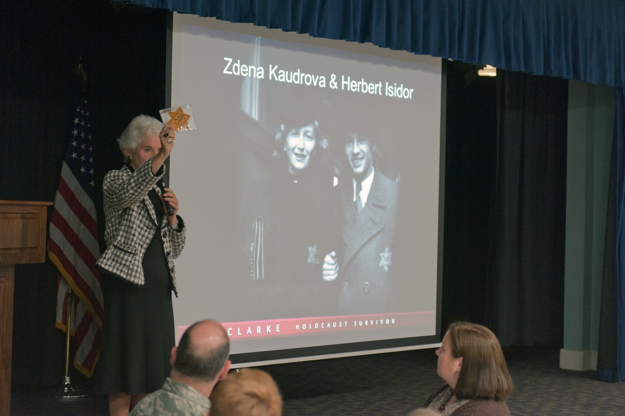 RAF ALCONBURY, United Kingdom – Eva Clarke shows member of the 501st Combat Support Wing and 423rd Air Base Group a star her parents had to wear because they were Jewish during the Holocaust Remembrance Luncheon at the RAF Alconbury Community Activities Center April 8. A short time before her parents became prisoners of war, the Germans made it illegal for Jews to do many things, one of which was as minor as going to the movies. (U.S. Air Force photo by Staff Sgt. Brian Stives)