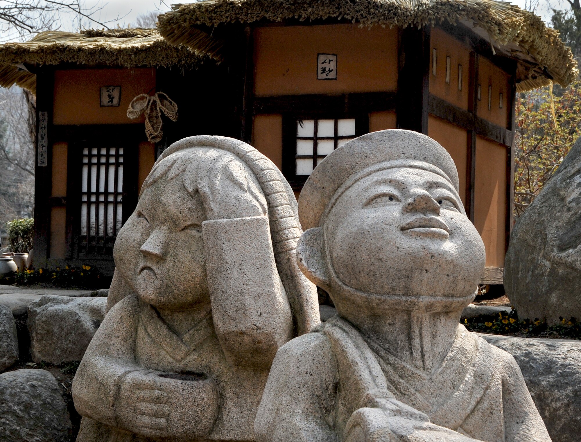 Two Korean statues face the entry of the pier as guests arrive to Nami Island with an Information Tickets and Travel trip April 8, 2013. Artists from around the world have contributed paintings, statues, pottery, instruments and hand-made glasswork that add to the innovative ambiance of Nami. (U.S. Air Force photo/Senior Airman Kristina Overton)