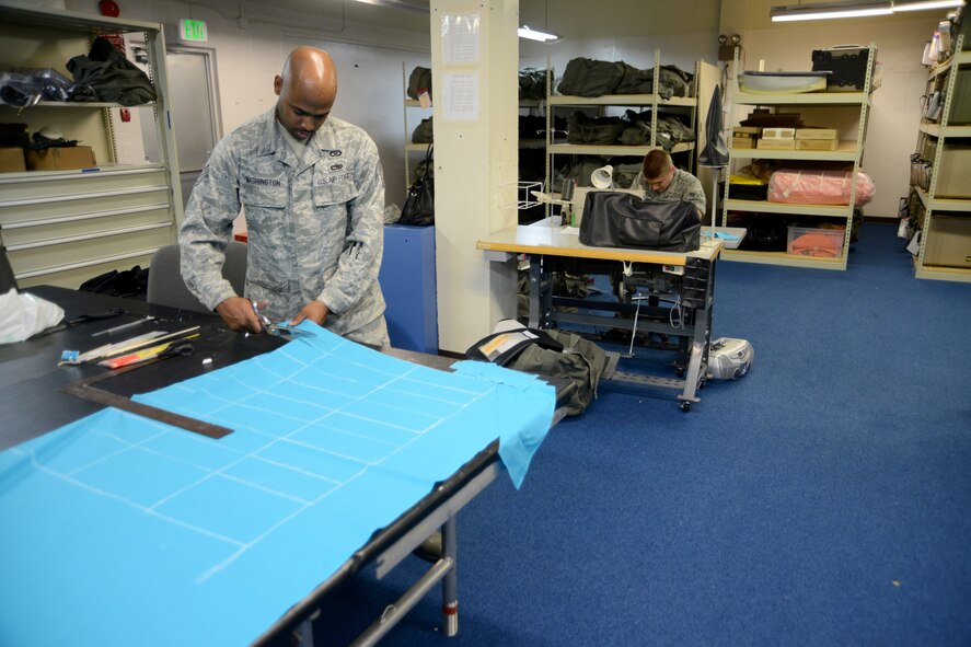 U.S. Air Force Tech Sgt. Roy Washington, 18th Operation Support Squadron NCOIC of air crew flight equipment, cuts fabric to be made into flags while Airman 1st Class Nick Meyers, an aircrew flight equipment apprentice, sews the flags into shape for Sexual Assault Awareness Month, March 13, 2013, Kadena Air Base, Japan. The flags are going to be available by donation at various places around the base and will be planted in the shape of a ribbon on Douglas Blvd to highlight survivors of sexual assault. (U.S. Air Force Photo/Tech Sgt. Jocelyn L. Rich-Pendracki)