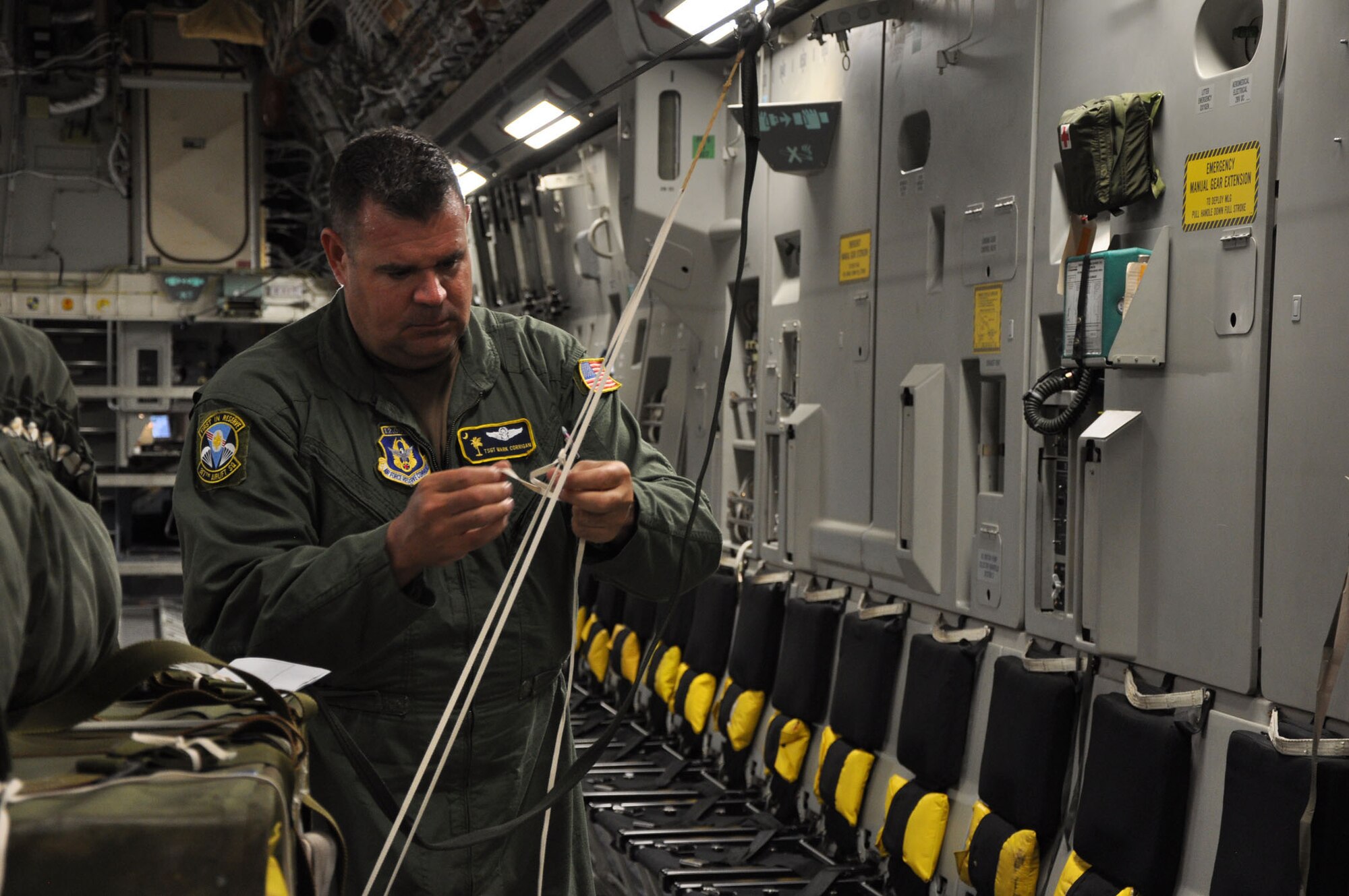 Tech. Sgt. Mark R. Corrigan, a loadmaster assigned to the 317th Airlift Squadron at Joint Base Charleston, S.C., makes final preparations on palletized cargo during a recent training mission. Aircrews from the 437th and 315th Airlift Wings at Joint Base Charleston conducted a large formation exercise (LFE) consisting of 13 C-17 Globemaster III aircraft Wednesday, April 9, 2013.  The mission included a variety of training exercises consisting of airdrops, aerial refueling and low level tactical training. These skills are needed at all times to ensure mission readiness, locally and globally. (U.S. Air Force photo/Senior Airman Bobby Pilch)