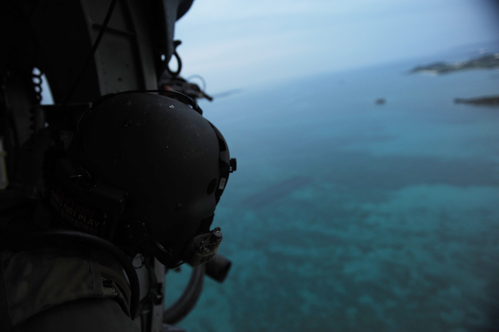 A crew chief from the 33rd Rescue Squadron looks out the door of an HH-60 Pave Hawk helicopter on Kadena Air Base, Japan, April 9, 2013. Because of its versatility, the HH-60G is used in a multitude of peace and wartime operations including search and rescue, and relief. (U.S. Air Force photo by Airman 1st Class Hailey R. Davis) 