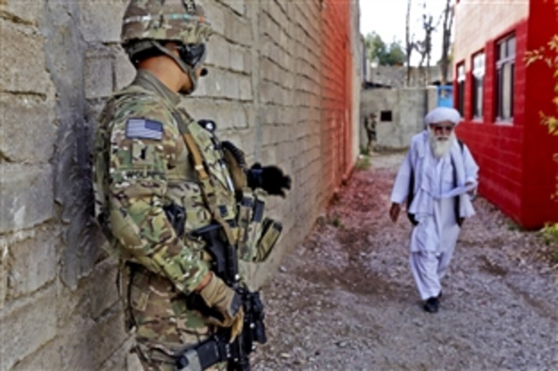 U.S. Army 1st Lt. Robert Wolfe waits to greet a Farah elder as he walks by during a meeting at the directorate of information and culture offices in Farah city, Afghanistan, April 10, 2013. Wolfe, a platoon leader, is assigned to Provincial Reconstruction Team Farah.