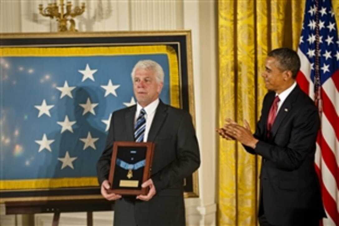 President Barack Obama awards the Medal of Honor to Army Chaplain (Capt.) Emil Kapaun, accepted posthumously by his nephew, Ray, during a ceremony in the East Room of the White House, April 11, 2013.