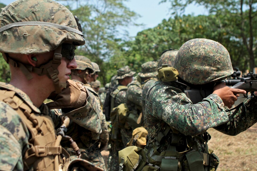 U.S. Marines look on as Philippine Marines fire their M-14 rifles at targets during a combat marksmanship program shoot as part of exercise Balikatan 2013 here, April 8. Marines and Sailors from Company B., Battalion Landing Team 1st Battalion, 5th Marines, 31st Marine Expeditionary Unit, and Philippine Marines fired side by side, improving their interoperability with one another. Balikatan 2013 helps maintain a high level of interoperability and enhances military-to-military relations and combined combat capabilities. The 31st MEU is the only continuously forward-deployed MEU and is the Marine Corps’ force in readiness in the Asia-Pacific region.