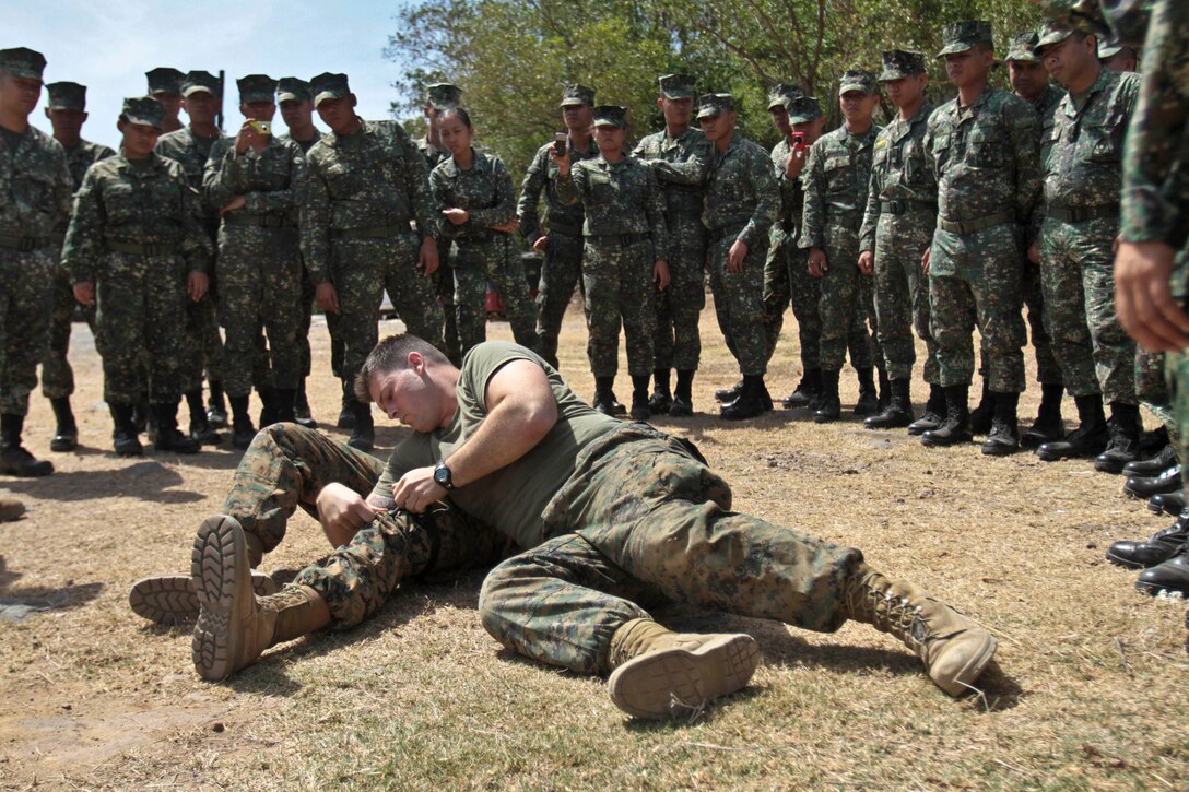 Petty Officer 2nd Class Ryan W. Marczynski, a corpsman with Battalion Landing Team 1st Battalion, 5th Marines, 31st Marine Expeditionary Unit, tightens a tourniquet on Petty Officer 2nd Class Aaron C. Walton, a corpsman with BLT 1/5, 31st MEU, during a combat lifesaver class given to their Philippine Marine counterparts as a part of exercise Balikatan 2013 here, April 11. The Balikatan series of exercises focuses on training both U.S. and Philippine armed forces to provide relief and assistance in the event of natural disasters and other crises that endanger public health and safety. The 31st MEU is the only continuously forward-deployed MEU and is the Marine Corps’ force in readiness in the Asia-Pacific region.