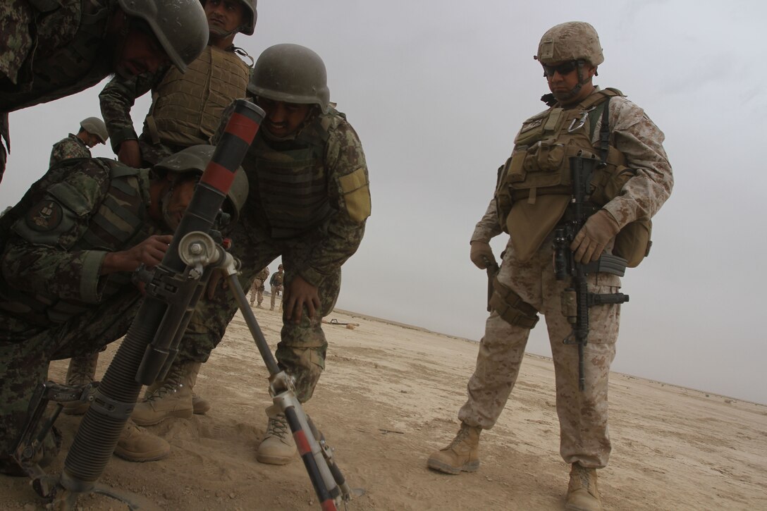 Gunnery Sgt. Joseph Smith, a Security Force Assistance Advisor Team artillery advisor and Santa Ana, Calif., native watches Afghan National Army infantry soldiers, who recently graduated ANA basic training, conduct M224 60mm mortar training operations at the Regional Military Training Center aboard Camp Shurabak, Washir District, Helmand Province, Afghanistan. Afghan National Army Maj. Gen. Sayeed Malook, the 215th Corps commanding general, and Maj. Gen. W. Lee Miller, the Regional Command (Southwest) commanding general were on hand to witness the training. The 215th Corps SFAAT Marines guide, assist and advise the 215th Corps, but Afghan soldiers conducted the training, while the SFAAT Marines ensured the ANA soldiers were meeting safety requirements.