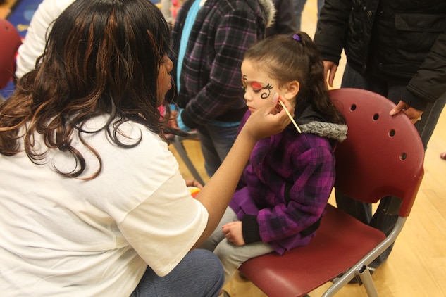 Sarah Harris, 4-years-old, gets her face painted by Tamika L. Curtis, th program assistant for the youth center, during the Eggstravaganza at the Laurel Bay Youth Center, March 23. Face painting was one of many activities offered during the celebration. 