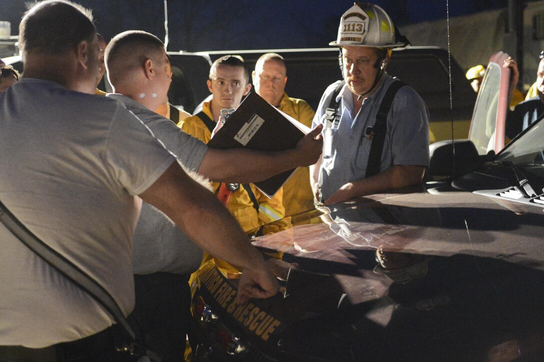 Charles Sullivan and Tracy Wheeler, assistant chiefs with the Marine Corps Base Quantico Fire Department, talk to a member of the  Fauquier County’s Lois Volunteer Fire Department about their plan to limit the spread of the wildfires on training areas on the west side of base on April 11, 2013. Three responders were sent to the hospital for heat exhaustion and smoke inhalation; all were later released. 