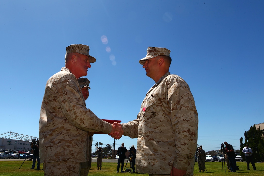 Maj. Gen. Steven Busby, left, commanding general of 3rd Marine Aircraft Wing, shakes hands with Gunnery Sgt. Kevin Anderson, right, the special security communications team chief with 4th Special Security Communications Team, Marine Wing Headquarters Squadron 3 and a Puyallup, Wash., native, during an award ceremony aboard Marine Corps Air Station Miramar, Calif., April 11. Anderson received the Bronze Star for actions while deployed to Afghanistan with Marine Corps Forces Special Operations Command providing village stability operations from Nov. 2010 to June 2011.
