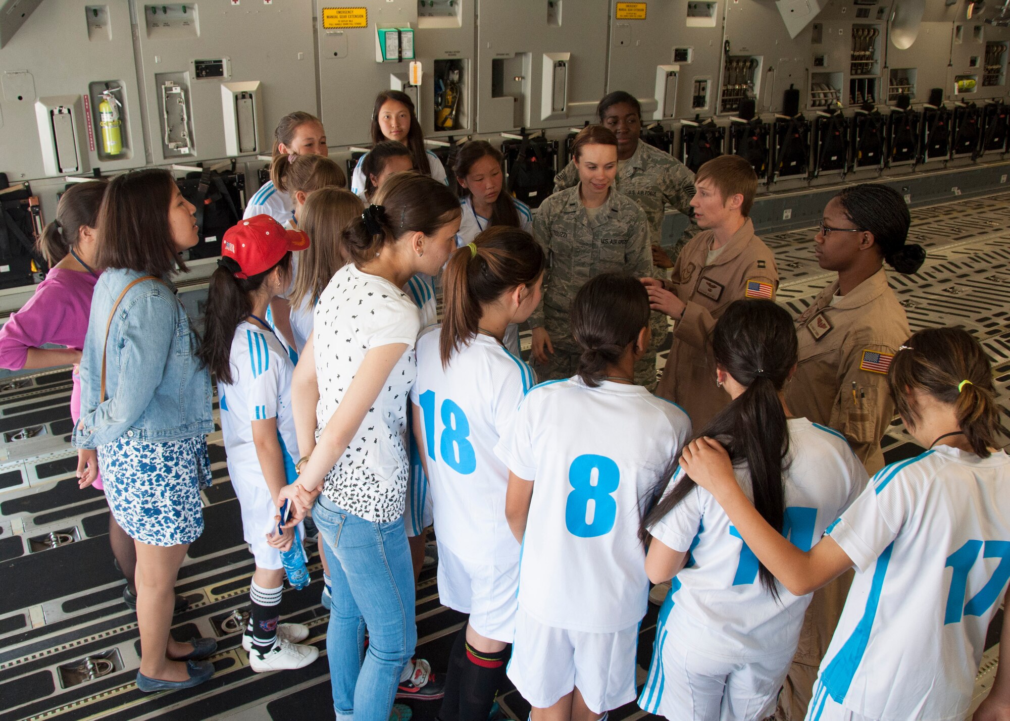 Young Kyrgyz soccer players and administrators from the Football Federation of Kyrgyz Republic gather inside a C-17 Globemaster III and listen as women aircrew members describe the aircraft's capabilities during a tour April 11, 2013, at Transit Center at Manas. The tour showcased women in leadership and non-traditional roles in an effort to inspire the girls in following their dreams. (U.S. Air Force photo/Tech. Sgt. Rachel Martinez)
