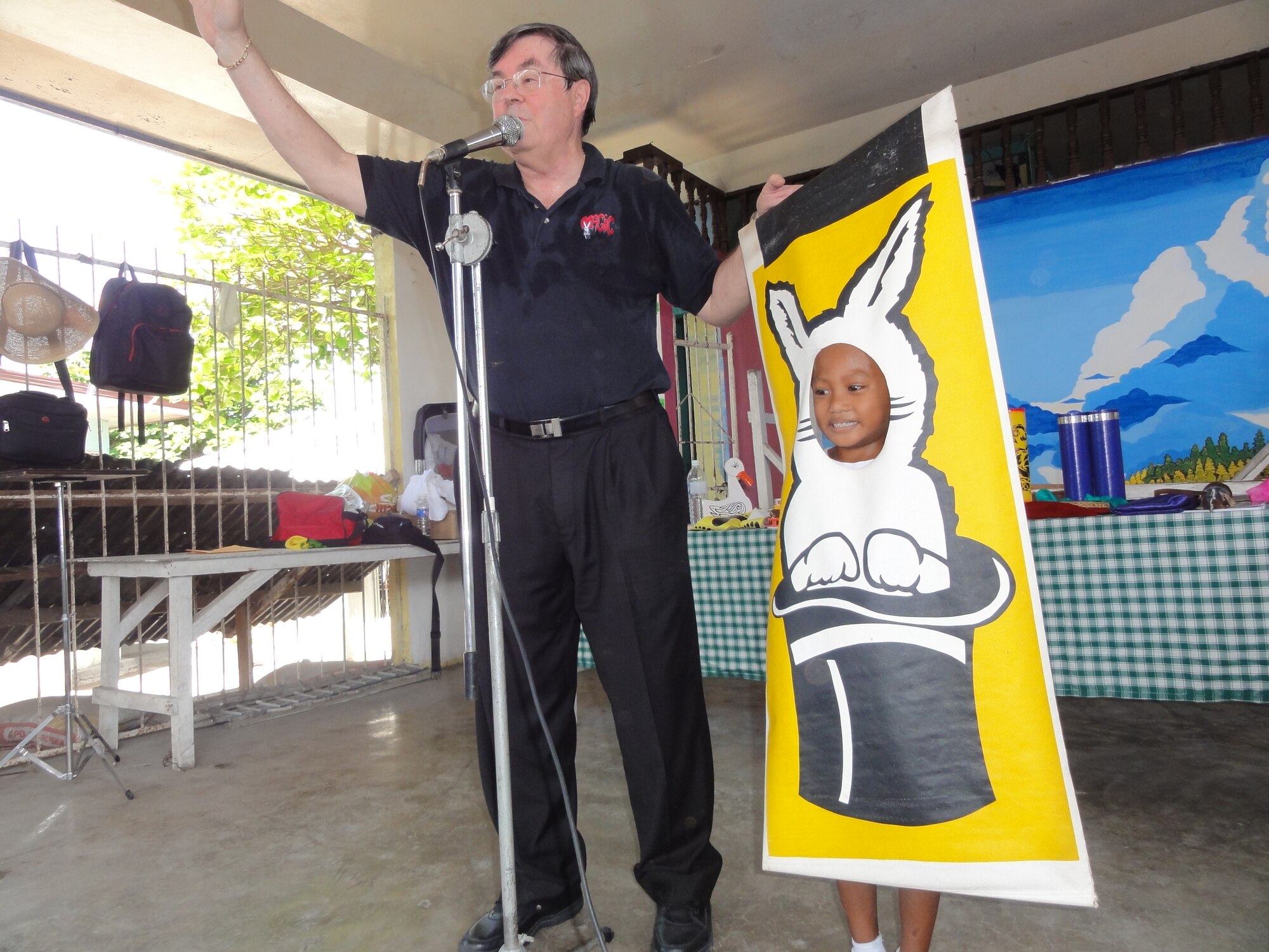 Glen Bailey, 15th Wing Plans, Programs and Inspection office, uses magic to turn his school-aged assistant into a rabbit during his magic show at an elementary school in Barangay Catituban, Philippines, March 7, 2013. The 50 minute show was one of three Bailey and his team performed while on a volunteer trip to provide medical aid to impoverished communities with the Aloha Medical Mission. In addition to the school shows, Bailey also performed for patients and their families at the local hospitals. (Courtesy photo)