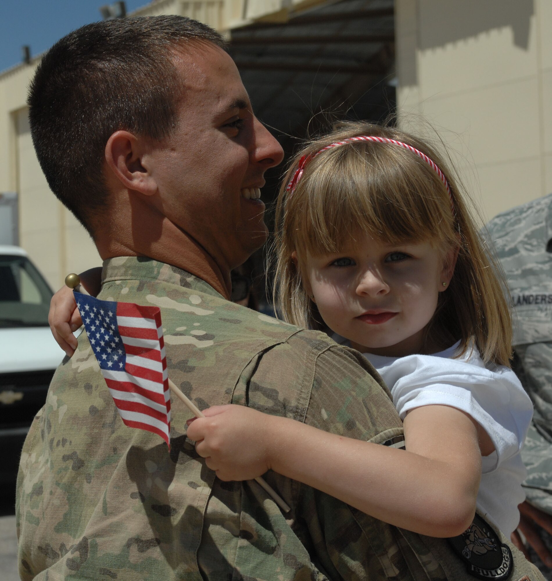U.S. Air Force Staff Sgt. Keith Whipple, 355th Maintenance Group, holds his daughter at Davis-Monthan Air Force Base, April 11, 2013. Whipple returned from a six-month deployment in Bagram Airbase, Afghanistan in support of Operation Enduring Freedom. (U.S. Air Force photo by Airman 1st Class Betty R. Chevalier/released)