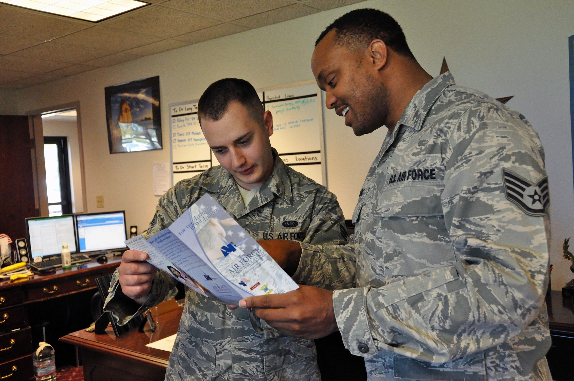 Staff Sgt. Brandon Wiggins, 60th Air Mobility Wing Protocol representative and wing staff Air Force Assistance Fund representative, informs his coworker, Senior Airman Ian Stevens of the great benefits AFAF has available for past and present military members and their families. (U.S. Air Force photo/Airman 1st Class Madelyn Brown).
