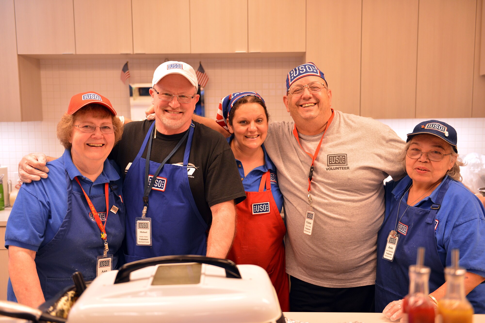 USO volunteers enjoy a moment of rest during the “No Dough Dinner” night, April 11, 2013, at Joint Base Lewis-McChord, Wash. The USO's new program offers Airmen and their families a free dinner one night toward the end of each pay period. (U.S. Air Force photo/Airman 1st Class Jacob Jimenez)