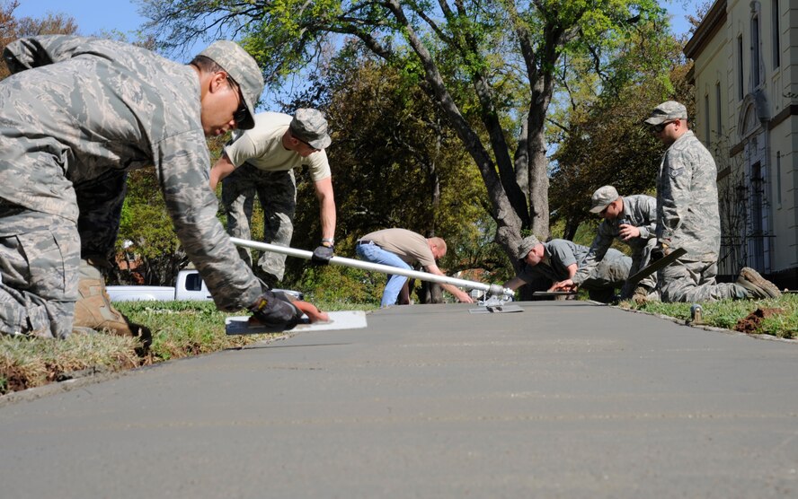 Airmen from the 2nd Civil Engineer Squadron Heavy Repair section smooth out a freshly laid sidewalk on Barksdale Air Force Base, La., April 12, 2013. Airmen from 2 CES excavated a worn out sidewalk to lay down a new one as part of a base beautification project. (U.S. Air Force photo/Airman 1st Class Andrew Moua)