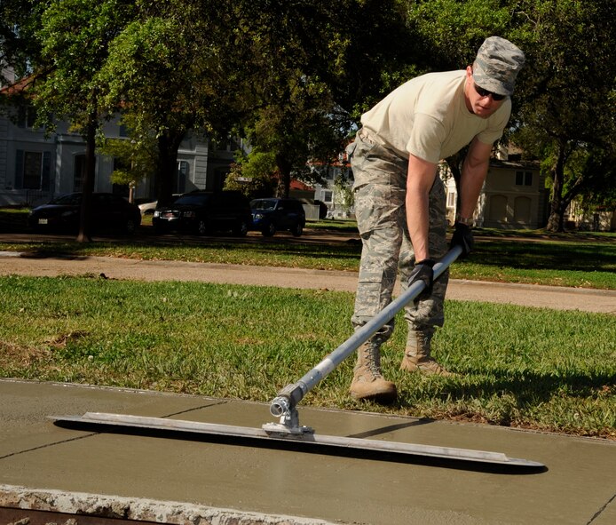 Tech. Sgt. David Blankenship, 2nd Civil Engineer Squadron Heavy Repair Pavement and Equipment supervisor, smooths over concrete on Barksdale Air Force Base, La., April 12, 2013. Airmen from 2 CES excavated a worn down sidewalk to lay down a new one as part of a base beautification project. (U.S. Air Force photo/Airman 1st Class Andrew Moua)