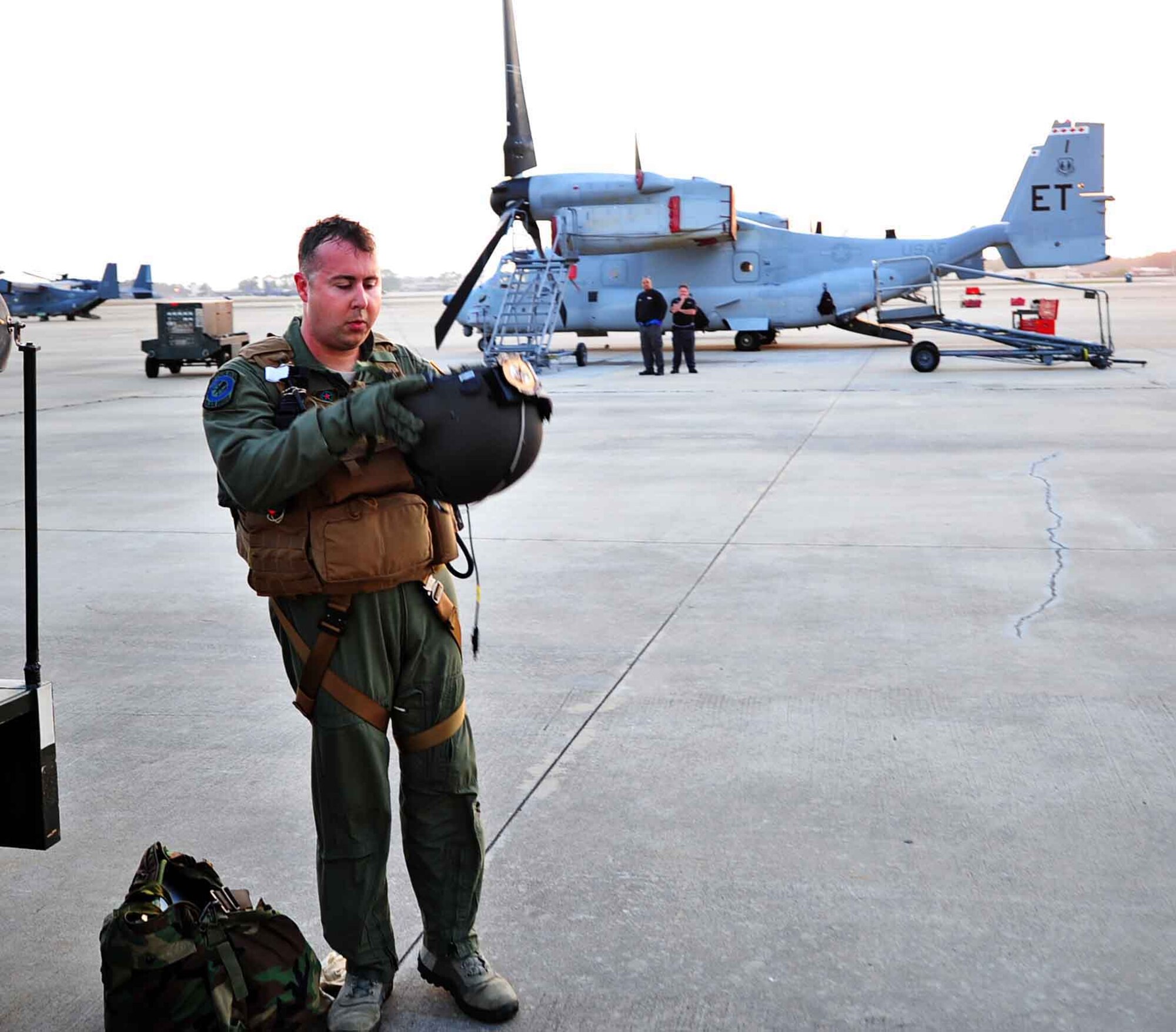U.S. Air Force Tech. Sgt. Christofer Curtis, CV-22 flight engineer of 8th Special Operations Squadron, inspects his helmet after his first flight back to regaining his flight status on Hurlburt Field, Fla., April 8, 2013. The CV-22 Osprey crashed in Zabul Province and left him with significant blood loss, as well as multiple fractures to his back, face, legs, left arm and pelvis. (U.S. Air Force photo illustration/Senior Airman Desiree Whitney Moye)