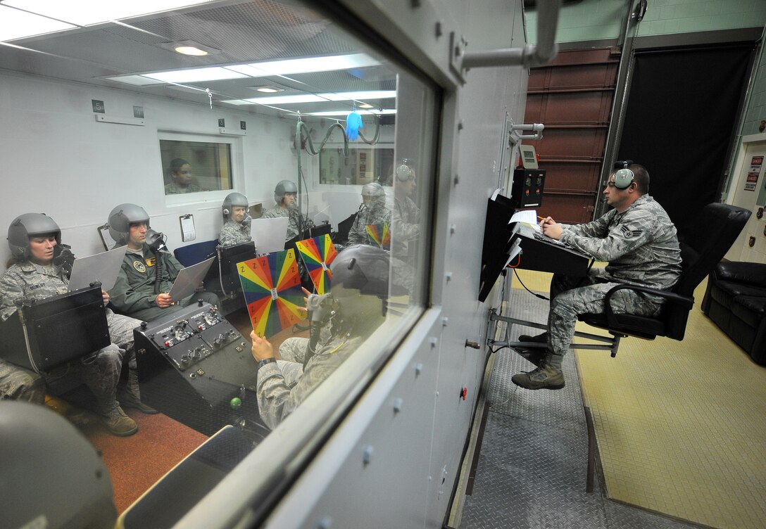 U.S. Air Force Senior Airman Kyle Long, an aerospace and operational physiologist technician from Shaw Air Force Base, S.C., monitors Airmen sitting inside a high-altitude pressure chamber April 4 at Offutt Air Force Base, Neb. This is the last group of Airmen to take their training in this chamber at Offutt, which has been in place since 1957 and built out of World War II battleships. Slowly these types of altitude chambers are being phased out by newer technologies.  (U.S. Air Force Photo by Josh Plueger/Released)