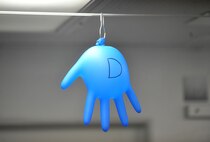 A slowly inflating medical glove hangs from the ceiling of a high-altitude pressure chamber to visually remind Airman what is happening to the gasses inside their bodies as they ascend to higher altitudes during a training session April 4 at Offutt Air Force Base, Neb. The altitude tests allow Airmen to experience and learn how to deal with physiological changes that affect the body at high altitude such as trapped gasses, decompression sickness and hypoxia.  (U.S. Air Force Photo by Josh Plueger/Released)