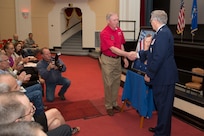 U.S. Air Force Ret. Col. Gary P. Baber and Ret. Maj. General William P. Acker shake hands after unveiling the painting to honor the late Brigadier General Kenneth Fleenor. The annual Freedom Flyers Reunion—a celebration of repatriated Vietnam prisoners of war—took place at Joint Base San Antonio-Randolph April 12.  It began with a theater dedication to honor Fleenor, a former F-4 pilot who was held captive as a prisoner of war in Vietnam for five years.   (U.S. Air Force photo by Joshua Rodriguez) (released)