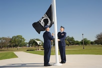 U.S. Air Force Maj. Mark Fogel and Capt. John Scott, both from the 560th Flying Training Squadron, raise the Prisoner of War flag at Heritage Park April 12 during the flag raising and wreath laying ceremony at Joint Base San Antonio-Randolph. The reunion is a celebration of repatriated Vietnam prisoners of war. The 560th Flying Training Squadron gave American pilots, who returned in 1973 from imprisonment in North Vietnam, their “freedom flight” to honor their return.  (U.S. Air Force photo by Melissa Peterson)