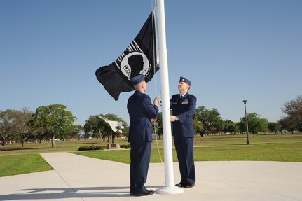 U.S. Air Force Maj. Mark Fogel and Capt. John Scott, both from the 560th Flying Training Squadron, raise the Prisoner of War flag at Heritage Park April 12 during the flag raising and wreath laying ceremony at Joint Base San Antonio-Randolph. The reunion is a celebration of repatriated Vietnam prisoners of war. The 560th Flying Training Squadron gave American pilots, who returned in 1973 from imprisonment in North Vietnam, their “freedom flight” to honor their return.  (U.S. Air Force photo by Melissa Peterson)