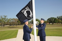 U.S. Air Force Maj. Mark Fogel and Capt. John Scott, both from the 560th Flying Training Squadron, raise the Prisoner of War flag at Heritage Park April 12 during the flag raising and wreath laying ceremony at Joint Base San Antonio-Randolph. The reunion is a celebration of repatriated Vietnam prisoners of war. The 560th Flying Training Squadron gave American pilots, who returned in 1973 from imprisonment in North Vietnam, their “freedom flight” to honor their return.  (U.S. Air Force photo by Melissa Peterson)