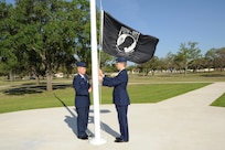 U.S. Air Force Maj. Mark Fogel and Capt. John Scott, both from the 560th Flying Training Squadron, raise the Prisoner of War flag at Heritage Park April 12 during the flag raising and wreath laying ceremony at Joint Base San Antonio-Randolph. The reunion is a celebration of repatriated Vietnam prisoners of war. The 560th Flying Training Squadron gave American pilots, who returned in 1973 from imprisonment in North Vietnam, their “freedom flight” to honor their return.  (U.S. Air Force photo by Melissa Peterson)