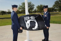 U.S. Air Force Maj. Mark Fogel and Capt. John Scott, both from the 560th Flying Training Squadron, raise the Prisoner of War flag at Heritage Park April 12 during the flag raising and wreath laying ceremony at Joint Base San Antonio-Randolph. The reunion is a celebration of repatriated Vietnam prisoners of war. The 560th Flying Training Squadron gave American pilots, who returned in 1973 from imprisonment in North Vietnam, their “freedom flight” to honor their return.  (U.S. Air Force photo by Melissa Peterson)