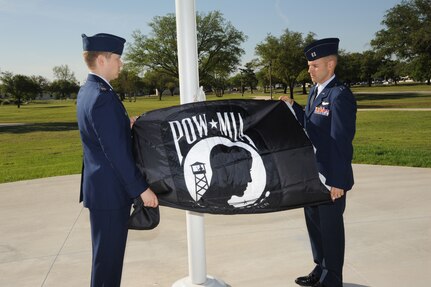 U.S. Air Force Maj. Mark Fogel and Capt. John Scott, both from the 560th Flying Training Squadron, raise the Prisoner of War flag at Heritage Park April 12 during the flag raising and wreath laying ceremony at Joint Base San Antonio-Randolph. The reunion is a celebration of repatriated Vietnam prisoners of war. The 560th Flying Training Squadron gave American pilots, who returned in 1973 from imprisonment in North Vietnam, their “freedom flight” to honor their return.  (U.S. Air Force photo by Melissa Peterson)