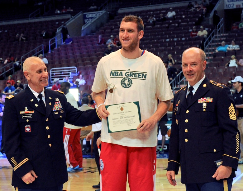 Lt. Col. Jeff Blankenship, 1104th Mobility Support Battalion commander, and Command Sgt. Maj. Rick Beck, 1104th MSB command sergeant major, present Philadelphia 76ers' center, Spencer Hawes with the Commander's Award for Public Service April 10, 2013, at the Wells Fargo Center in Philadelphia. The senior leaders recognized Hawes for his contributions to support service members and their families. (U.S. Air Force photo by 2nd Lt. Alexis McGee/Released)