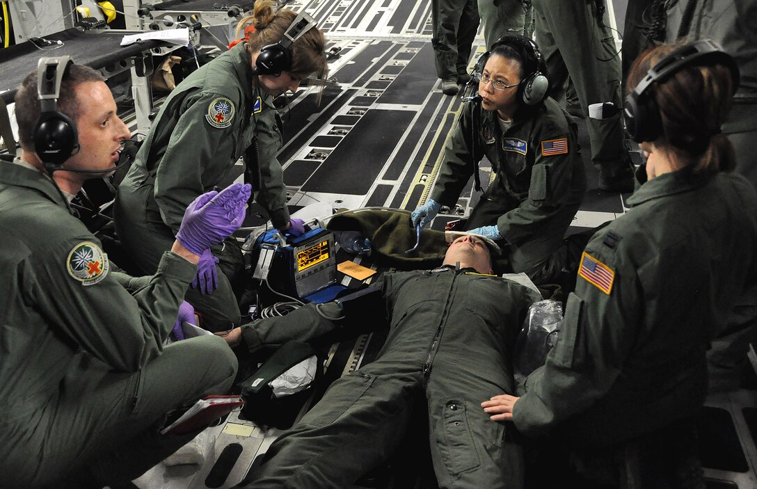 A team of Reservists from the 446th Aeromedical Evacuation Squadron treat Capt. Steven Smith, 446th AES flight nurse and training evaluator, during a C-17 training exercise April 7. Smith pretended to be a patient who fainted and vomited blood. This scenario was a test for a team of flight nurses and medical technicians. (U.S. Air Force Photo/Airman 1st Class Madelyn McCullough)