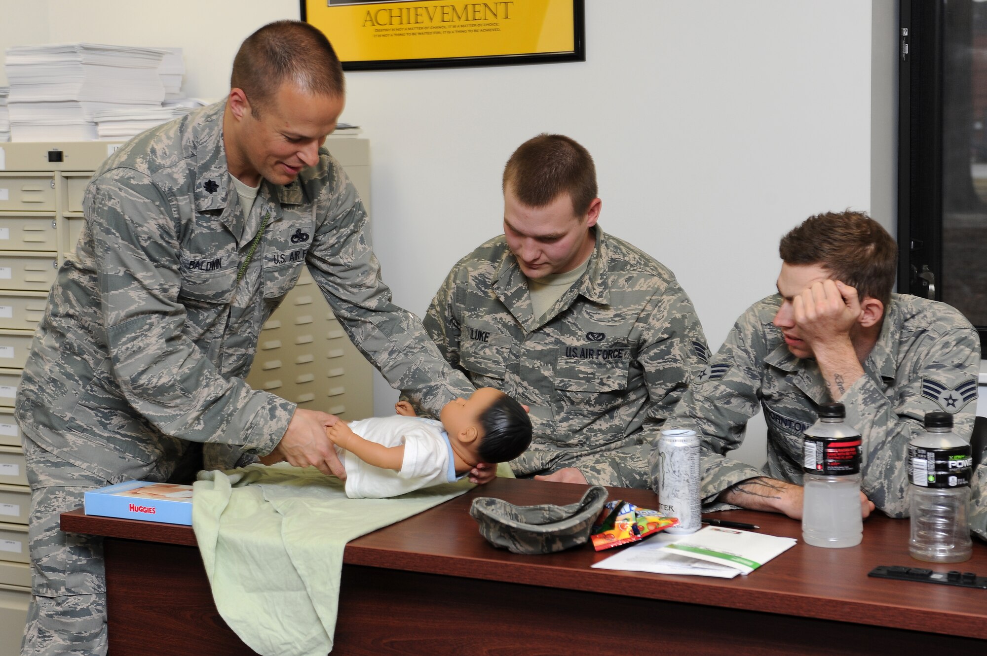 U.S. Air Force Lt. Col. Jeffery Baldwin, 4th Aircraft Maintenance Squadron commander, demonstrates how to properly swaddle a baby during Dads: The Basics 101, at the Family Life Center on Seymour Johnson Air Force Base, N.C., April 4, 2013. The class provided tips on what to expect, and how to prepare for, parenthood. (U.S. Air Force photo by Airman 1st Class John Nieves Camacho/Released)