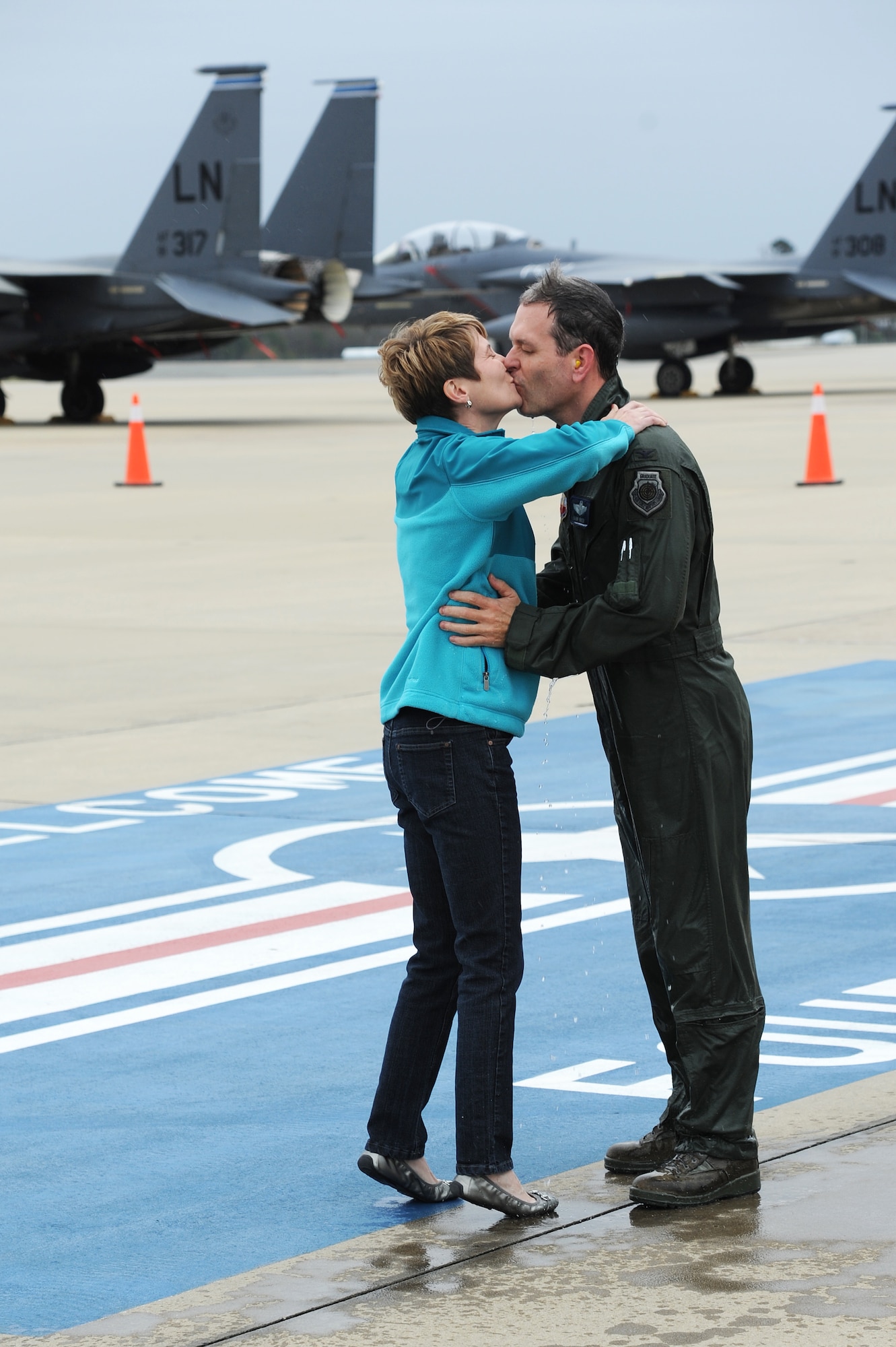 U.S. Air Force Col. Vann Green, 4th Fighter Wing vice commander, kisses his wife, Jan Green, after she sprayed him with a fire hose on the flight line following his final flight on Seymour Johnson Air Force Base, N.C., April 4, 2013.  Green will leave Team Seymour to become the Chief of Strategic Studies Group for the Chief of Staff of the Air Force.  (U.S. Air Force photo by Airman 1st Class Brittain Crolley/Released)