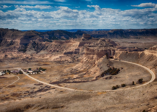 The visitor center and the start of Summit Road can be seen climbing up the bluffs from the south overlook on the summit of Scotts Bluff National Monument. (U.S. Air Force photo by Matt Bilden)