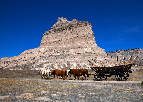 A static display of a horse drawn wagon is shown in front of Eagle Rock along the original Overland Trail at Scotts Bluff National Monument, Neb. (U.S. Air Force photo by Matt Bilden)