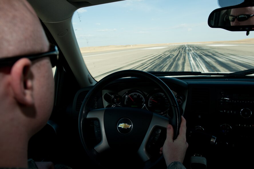 Airman 1st Class Steven Singleton, 28th Operation Support Squadron airfield management specialist, visually scans the active runway for foreign object and debris during a FOD check on Ellsworth Air Force Base, S.D., April 4, 2013. Airfield Management Airmen are required to complete a FOD check every two hours to guarantee the airfield is free from any obstructions and eliminate potential FOD hazards. (U.S. Air Force photo by Airman 1st Class Kate Thornton-Maurer/Released)  